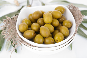 Olives in bowl with branch close up