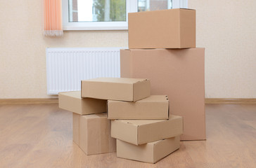 Empty room with stack of cartons: moving house concept