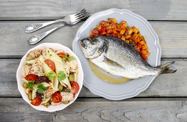 Top view of gilt-head bream fish on wooden background. Symbol of