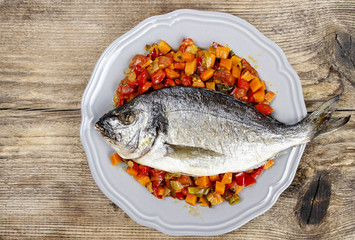 Top view of gilt-head bream fish on wooden background