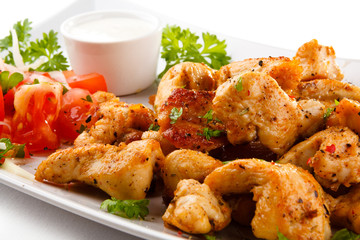 Grilled meat and vegetables on white background