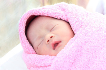 Asian new born infant sleep in towel.
