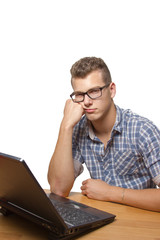 Upset and bored boy sitting in front of his laptop - 57882352
