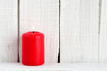 Red candle on wooden background