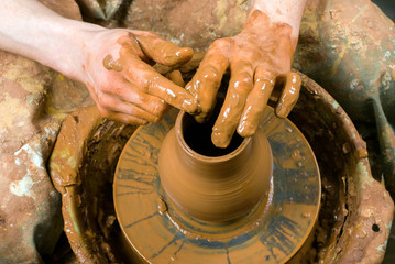 hands of a potter, creating an earthen jar on the circle