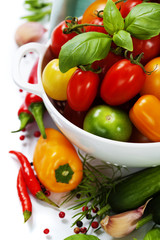 Fototapeta na wymiar Różne pomidory i warzywa w durszlak