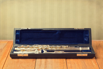 Musical instrument flute in carrying case on wooden table