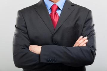 Unrecognizable businessman with folded arms