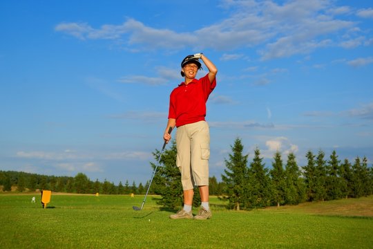 Golf, woman golfer observing the flight of the ball
