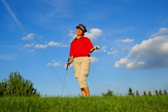 Golf, laughing woman golfer with a stick and a ball in his hand