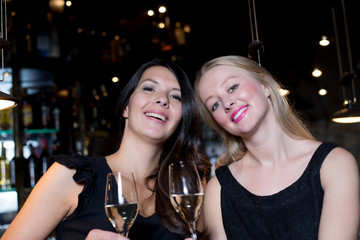 Two happy female friends toasting with champagne