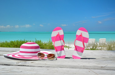 Hat, sunglasses and flip-flops against ocean. Exuma, Bahamas