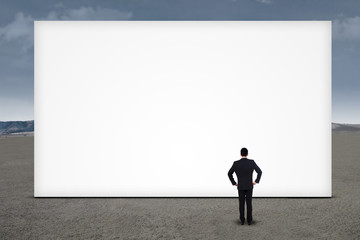 Businessman standing in front of empty board