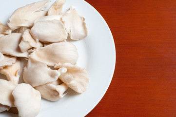 Fototapeta na wymiar raw mushrooms in a plate on wooden table