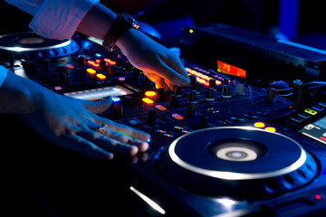 Obraz premium Hands of a DJ mixing music at a disco