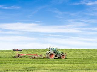 Obraz premium Tractor on green meadow