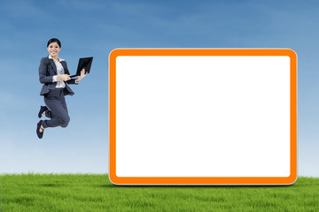 Happy businesswoman jumping and holding a notebook