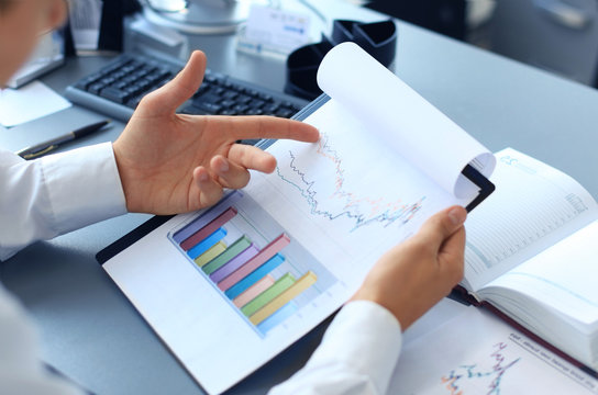 Close-up of graphs and charts analyzed by businessman