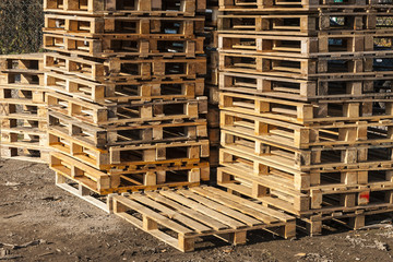 Wooden transport pallets in stacks ready for delivery.