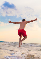 Fototapeta premium Happy man jumping on the beach