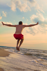 Obraz premium Happy man jumping on the beach