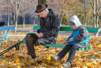 Young boy reading with his grandfather