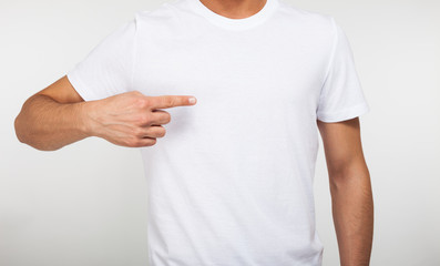 Man pointing his finger on a blank t-shirt - obrazy, fototapety, plakaty