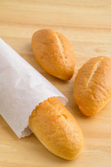 Bread in the paper bag on wooden table