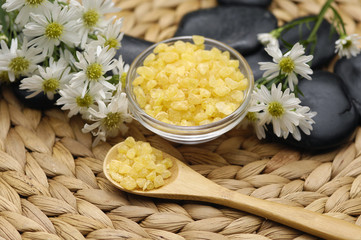 Fototapeta na wymiar salt with daisies flower and stones with on wicker mat