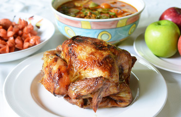 Fried chicken on a white plate with  Sausage and fruit on the ba