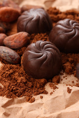 Composition of chocolate sweets and cocoa on brown background