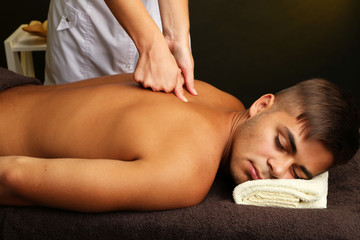 Obraz na płótnie Canvas Young man having back massage close up