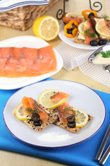 Salmon sandwiches on plate  on wooden table close-up