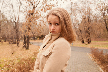 portrait of a beautiful girl in the park in autumn