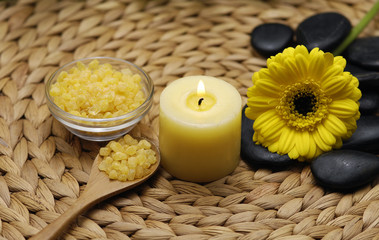 candle and daisies flower and bamboo leaf on wicker mat
