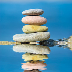 heap of pebbles reflected in a water