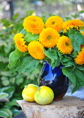 Bouquet of sunflowers are with the decorative pumpkins