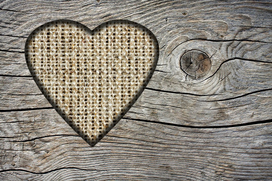 Background with a hole in the shape of heart and old wooden boar