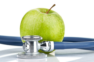 Medical stethoscope and apple isolated on white