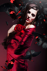 beautiful woman in red fabric with red rose and butterflies