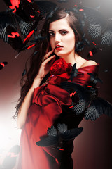 sexy woman in red fabric with red rose and butterflies