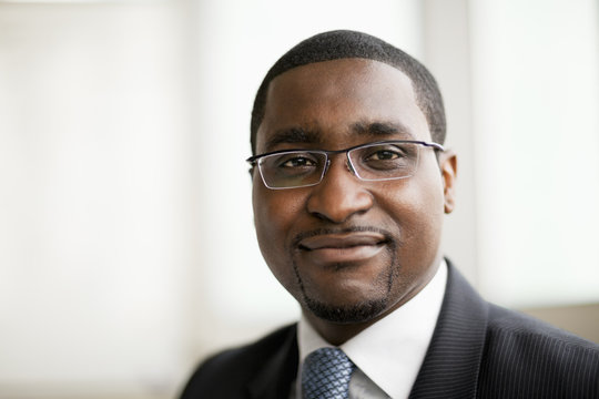 Portrait Of Smiling Businessman In Glasses, Head And Shoulders