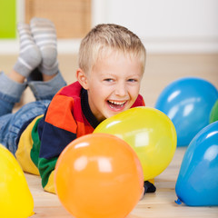 Fototapeta na wymiar lachender kleiner junge mit luftballons