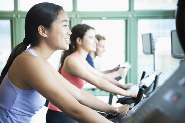 Fototapeta na wymiar Young women exercising on fitness bikes in the gym 