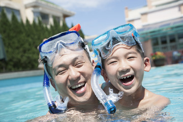 Portrait of father and son with snorkeling equipment in the pool - obrazy, fototapety, plakaty