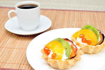 Fruit cake on a plate and a cup of coffee