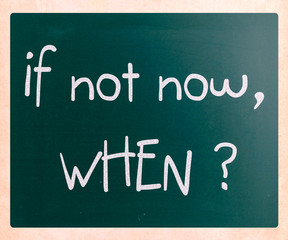 "If not now, when?" handwritten with white chalk on a blackboard