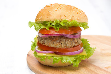 Burger with a vegetarian cutlet and fresh vegetables on board