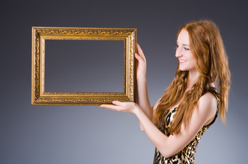 Redhead with picture frame against dark background