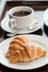 breakfast with cup of black coffee and croissants